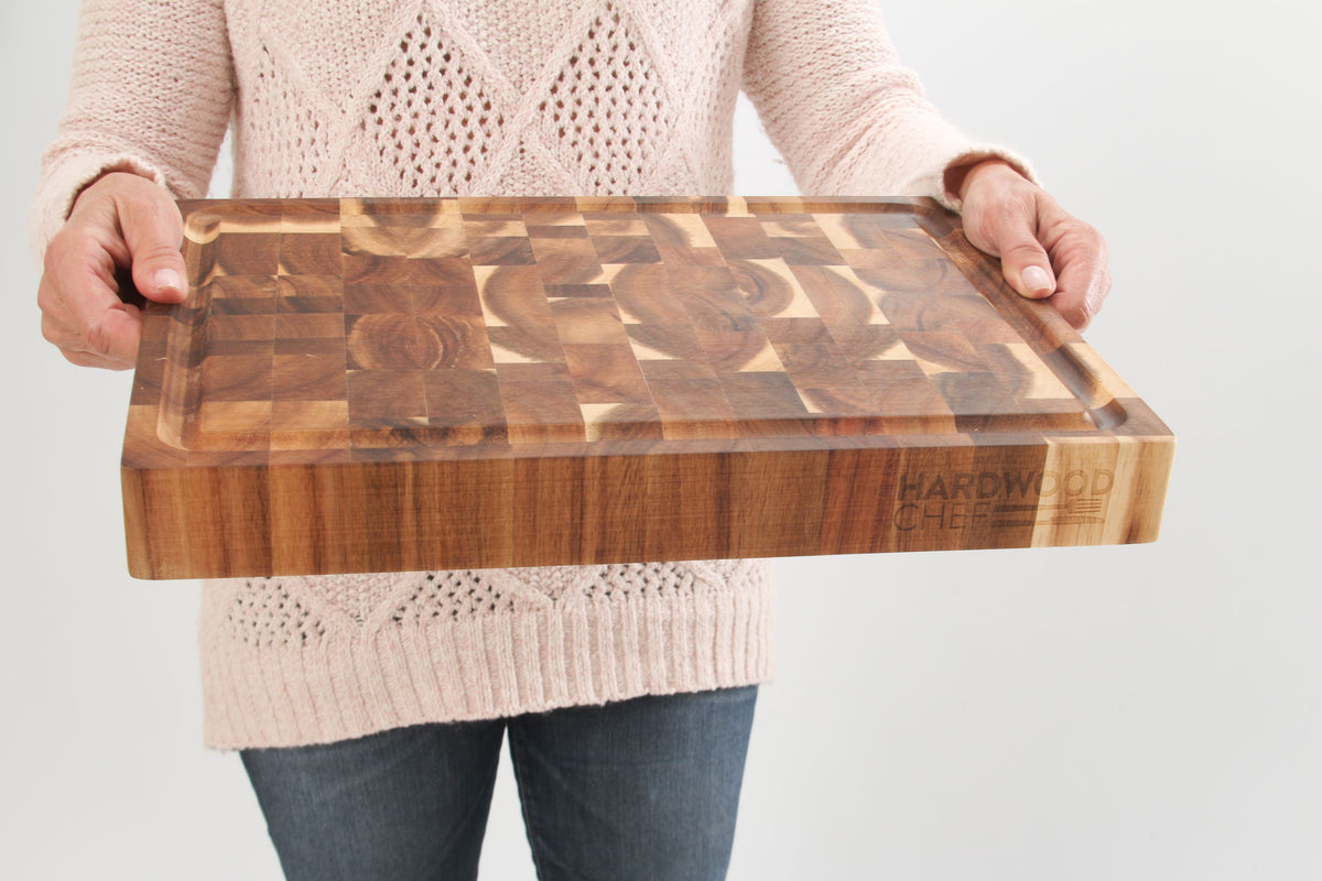 Person holding the thick acacia end grain board to show its size